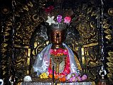 
An extremely ornate statue of Shakyamuni Buddha is the main image inside the main shrine of the Golden Temple in Patan.
